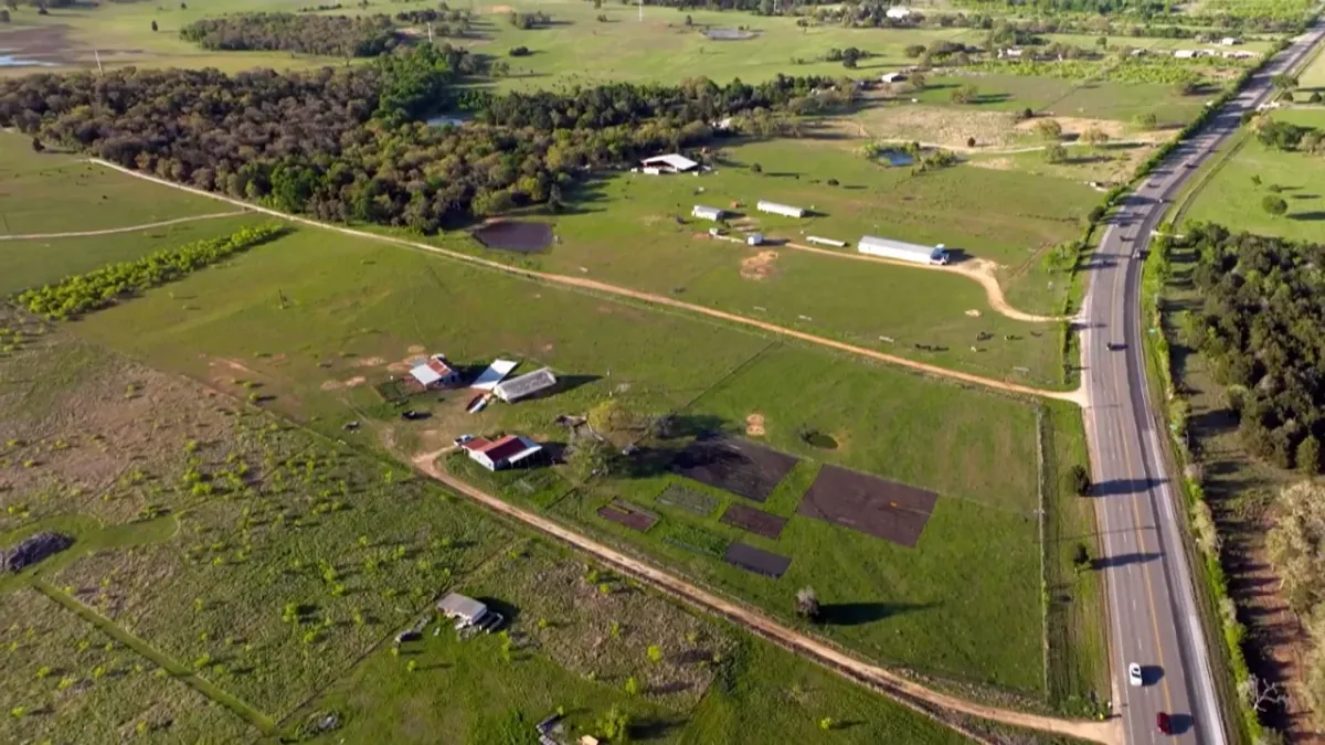 Aerial view of small ranches, fields and a highway in east Texas, a still from the film
