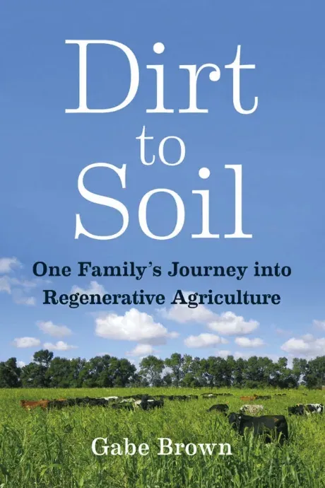 Front cover of Dirt to Soil by Gabe Brown: the white title over a blue sky, with cattle grazing a tall green cover crop below a tree line.