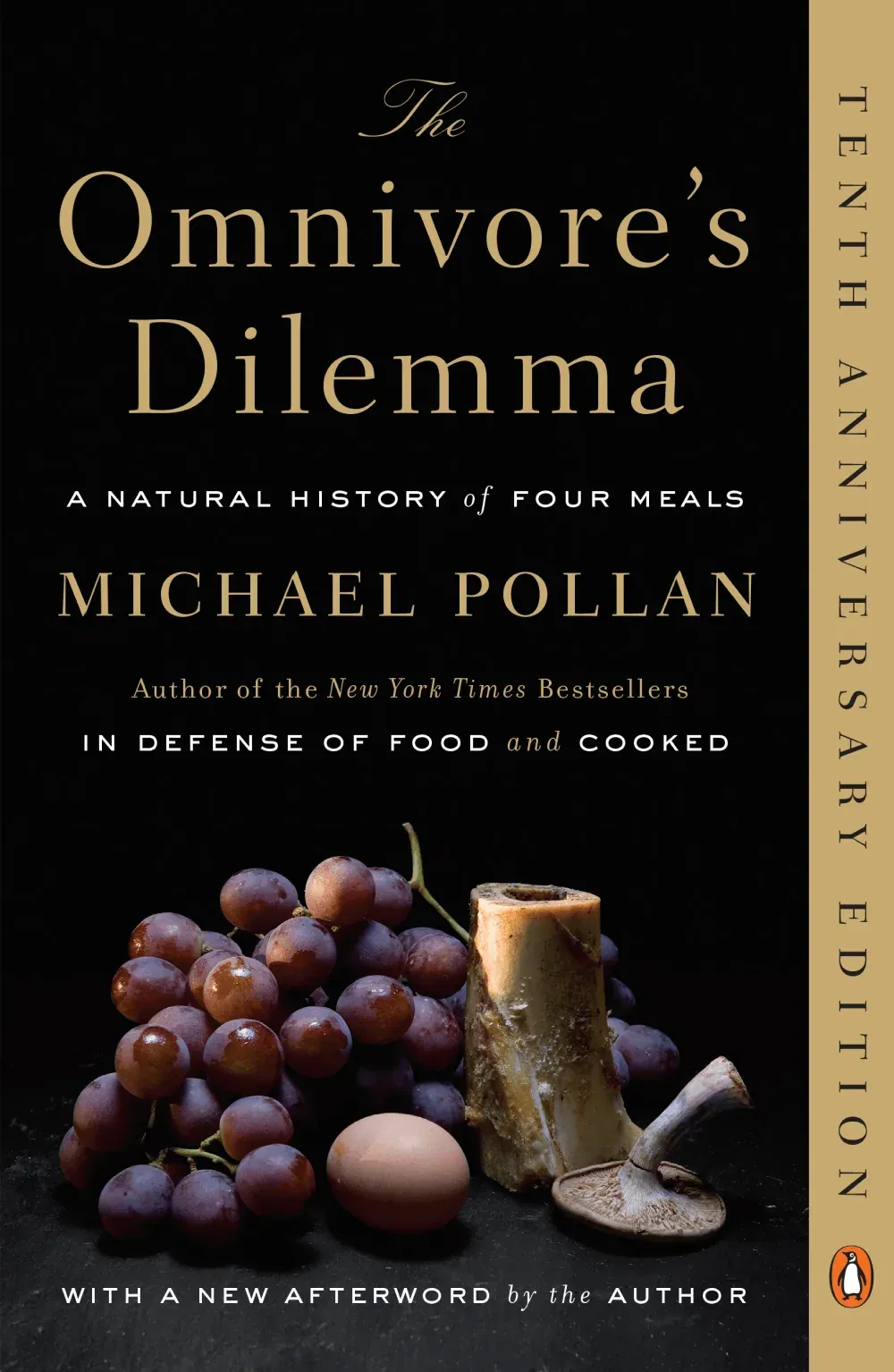 The Omnivore's Dilemma (Michael Pollan): Front cover of the Penguin Tenth Anniversary Edition of The Omnivore's Dilemma by Michael Pollan: grapes, an egg, a marrow bone and a mushroom on black with gold lettering.