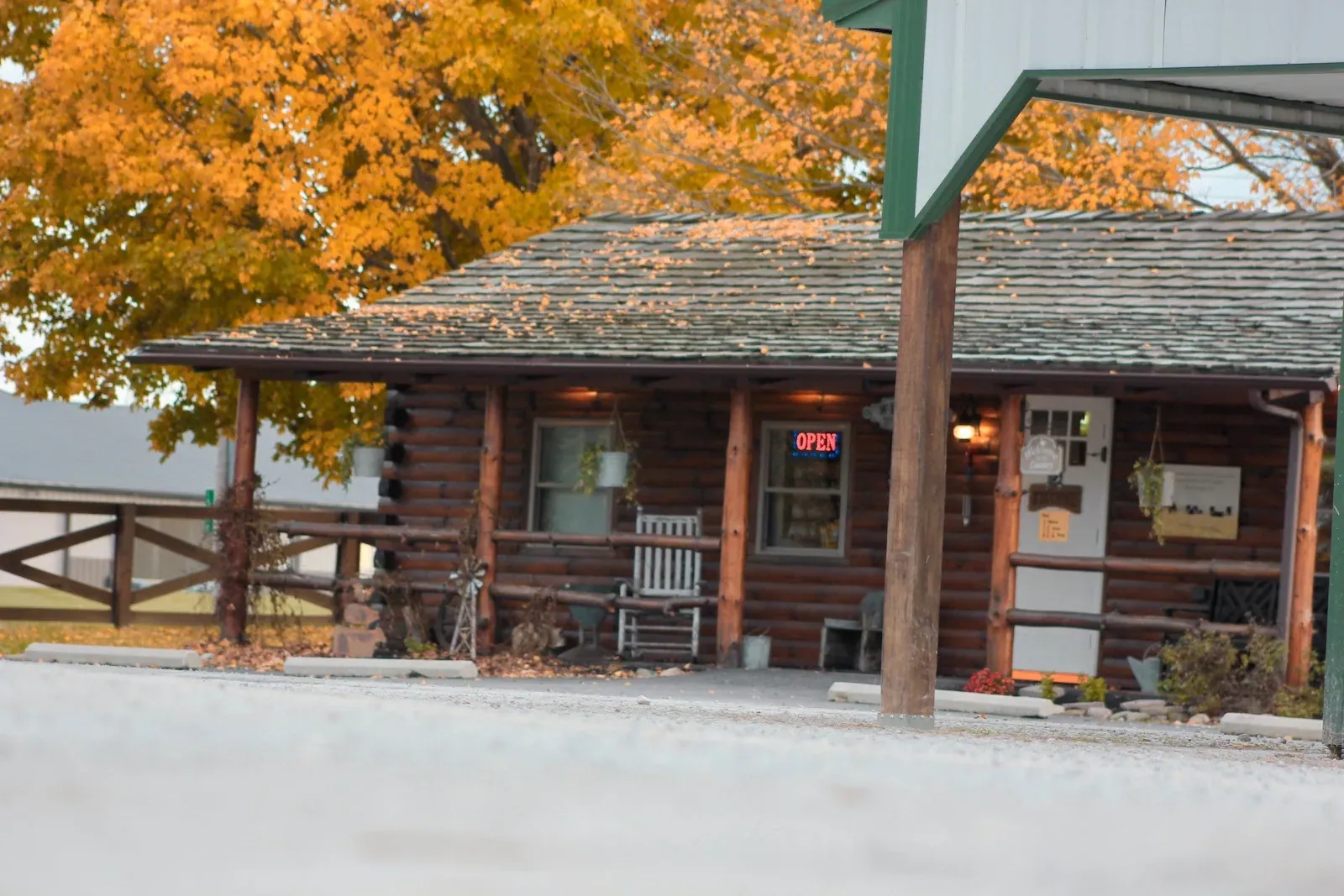 Seven Sons Farms: The farm's log-cabin farm store with a porch, framed by orange autumn foliage.