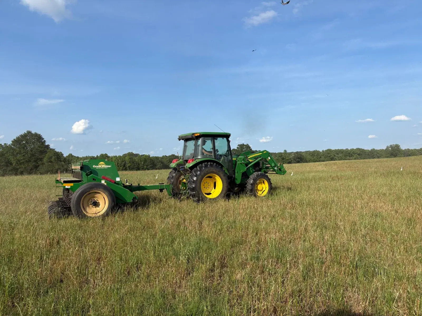 Kiss the Ground: A tractor pulls a grant-funded no-till drill across a pasture on the ranch of Kiss the Ground grant recipient Miles Brown (six-month grant update photo).