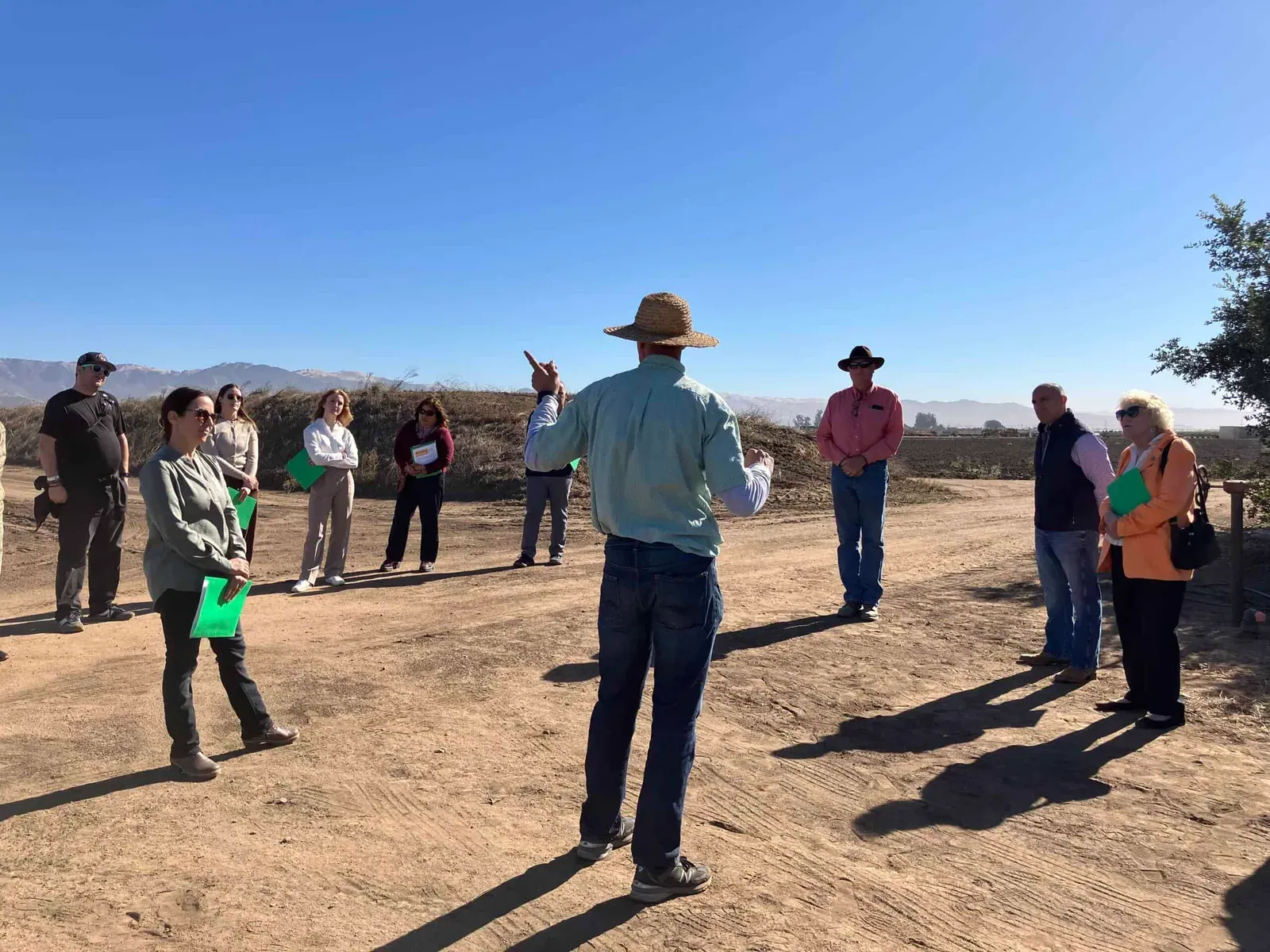 Organic Farming Research Foundation: USDA ARS researcher Dr. Eric Brennan addresses attendees standing in a circle on a bare field at the OFRF-hosted Congressional Organic Research Field Day in Salinas, California, October 2024.