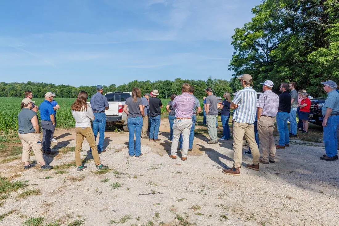 Soil Health Institute: Participants of a Soil Health Institute-led Farmers for Soil Health education meeting stand in a circle at the edge of a corn field during a farm tour in Glendale, Kentucky.