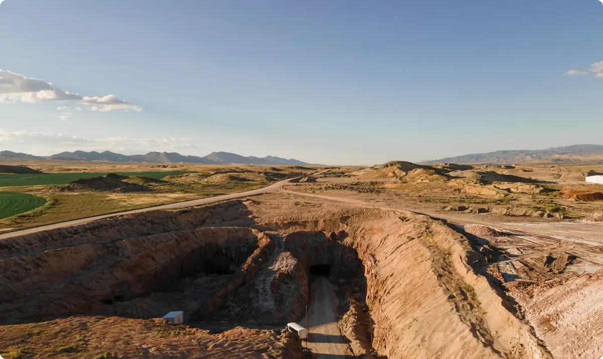 Redmond Agriculture: Redmond's ancient sea deposit mine in Central Utah, with the cut and mine entrance in the foreground and pasture and mountains behind.