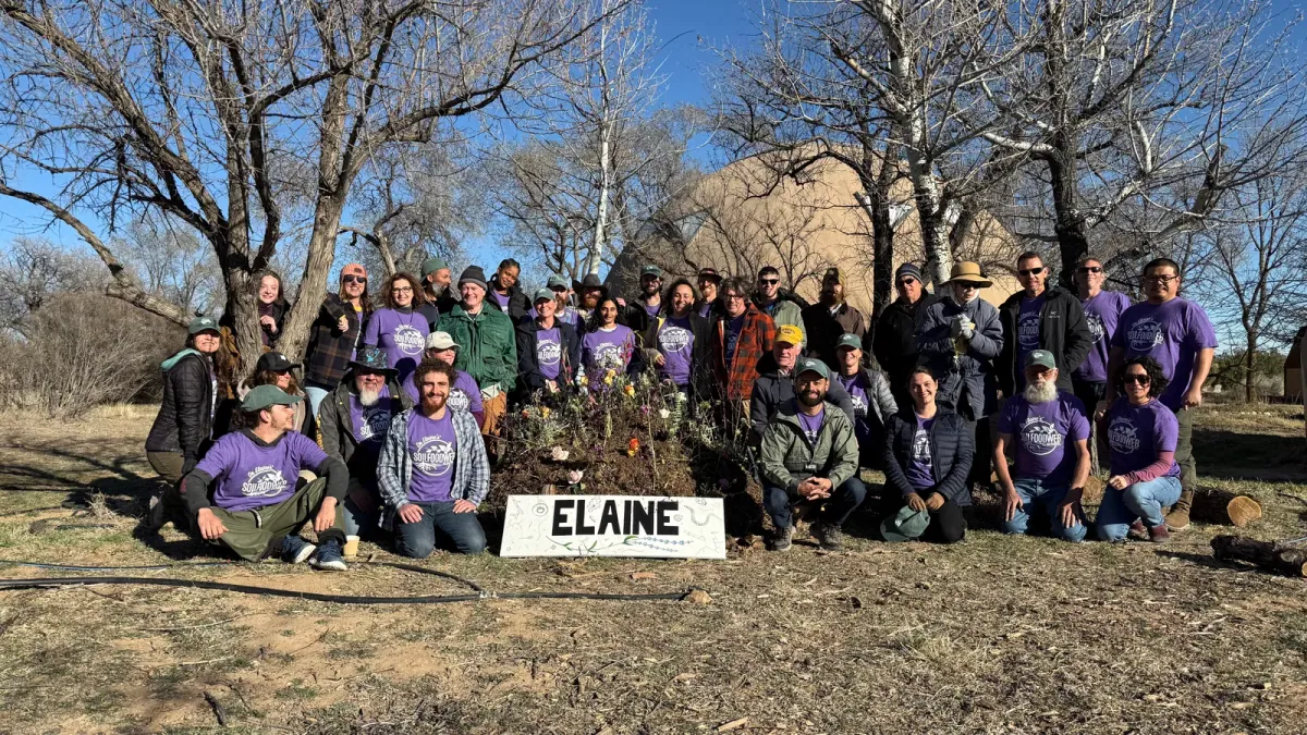 Soil Food Web School: Soil Food Web School community members in purple shirts gathered around a ceremonial compost pile built in memory of founder Dr. Elaine Ingham (posed group photo).